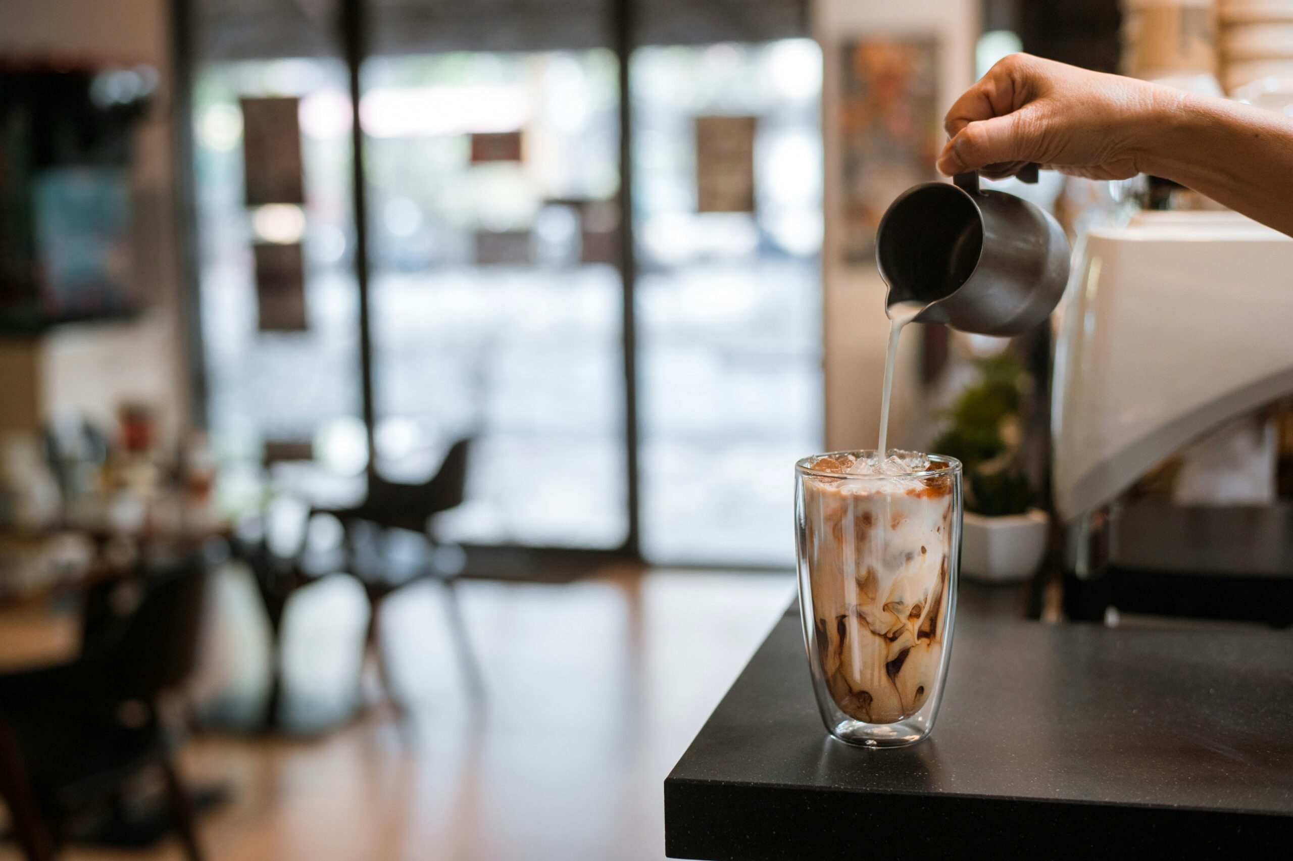 Barista pouring iced coffee.